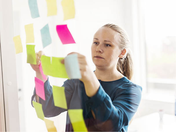 Workshop-Situation: Frau organisiert bunte Haftnotizen